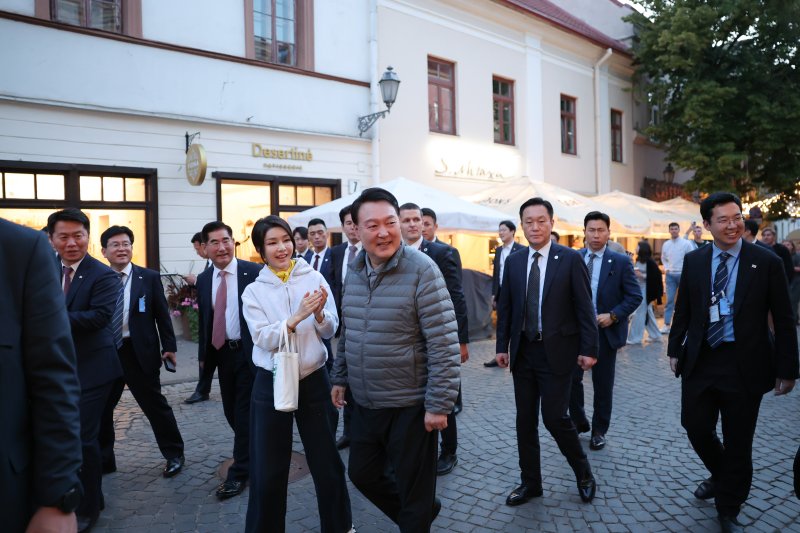 북대서양조약기구(NATO·나토) 정상회의 참석차 리투아니아를 방문 중인 윤석열 대통령과 김건희 여사가 10일(현지시간) 빌뉴스 구시가지를 산책하고 있다. 빌뉴스 구시가지는 유네스코에 의해 세계문화유산으로 등재된 곳이다. [공동취재] 연합뉴스