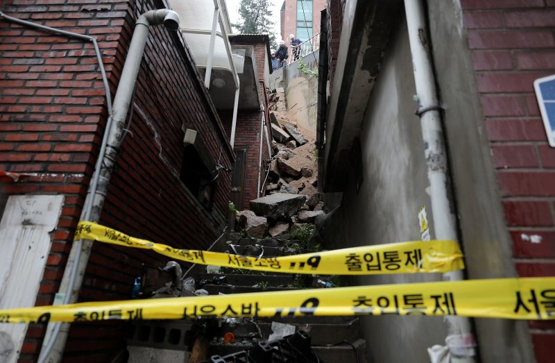 14일 서울 서대문구 연희동에서 구청 관계자들이 지난밤 폭우로 무너진 축대를 복구하고 있다. 이 사고로 인근 20가구 46명이 심야에 긴급 대피했다.뉴스1