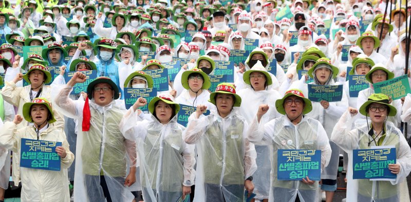 [서울=뉴시스] 조성봉 기자= 13일 오후 서울 종로구 동화면세점 인근 도로에서 열린 ‘간병비 해결, 간호사 대 환자수 1:5 직종별 인력기준 마련, 의사인력 확충, 불법의료 근절, 공공의료 확충, 노동개악 저지, 9.2 노정합의 이행’ 2023 보건의료노조 산별 총파업대회에서 참가자들이 구호를 외치고 있다. 2023.07.13. suncho21@newsis.com