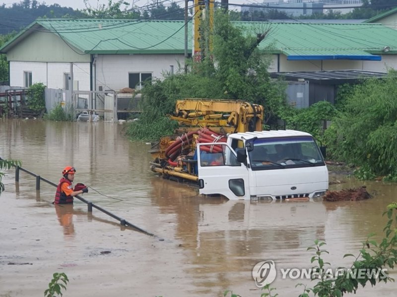 지난 13일 오후 경기 남양주시 수석동에서 집중호우로 물에 잠긴 차량에 대해 119대 대원들이 운전자 구조와 안전조치를 하고 있다. 남양주소방서 제공.