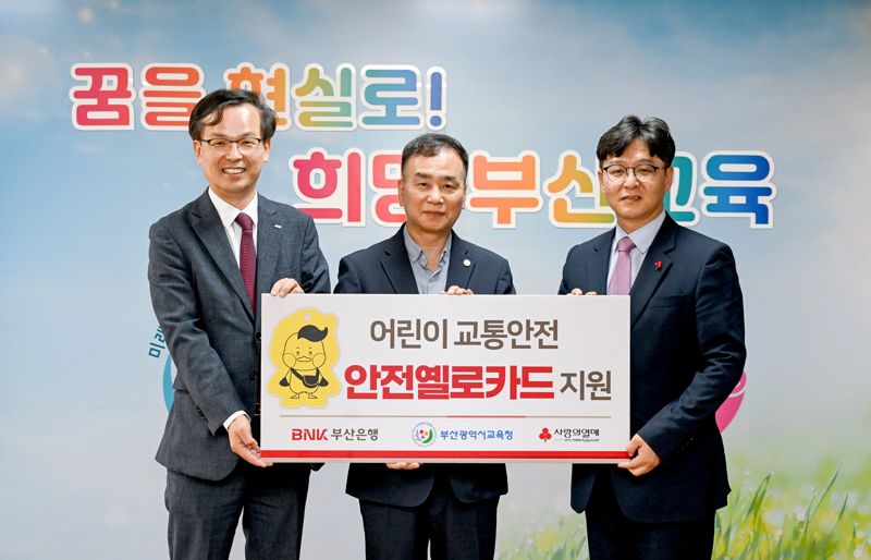 부산은행 강석래 경영기획본부장과 부산시교육청 김정태 기획국장, 부산사회복지공동모금회 박선욱 사무처장(왼쪽부터)이 안전옐로카드 전달식에서 기념사진을 촬영하고 있다./제공=부산은행