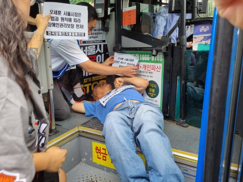 지난 17일 오후 1시께 서울 종로구 혜화동로터리 앞 버스전용차로에서 전국장애인차별철폐연대(전장연) 활동가들이 시내버스 탑승 요구 시위를 진행하고 있다. 뉴시스 제공