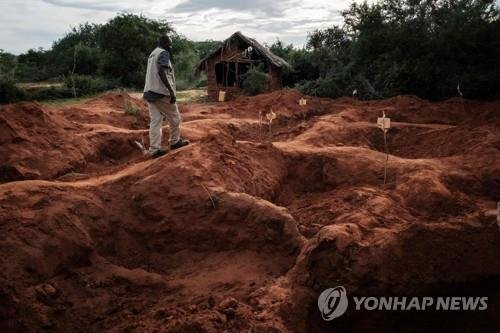 지난 4월 25일(현지시간) 케냐 지방 도시 말린디에 있는 기쁜소식 국제교회 인근 샤카홀라 숲에서 현지 범죄수사대 한 수사관이 "예수를 만나려면 굶어 죽어라"는 사이비 종교 지도자의 강요에 숨진 신도들의 시신이 발굴된 집단 매장지 위를 걷고 있다. /사진=연합뉴스