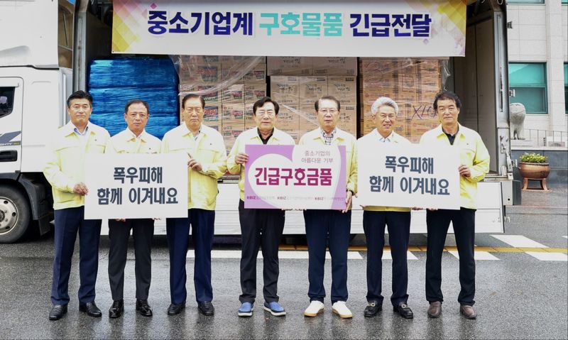 18일 충청북도 괴산군청에서 폭우 피해를 입은 이재민에게 전달하기 위한 긴급구호 물품 전달식에서 손인국 중기사랑나눔재단 이사장(왼쪽 세번째부터) 김기문 중기중앙회장, 송인헌 괴산군수 등 참석자들이 기념촬영을 하고 있다. 중기중앙회 제공.