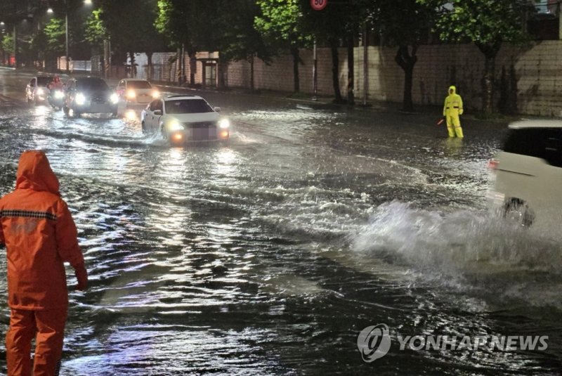 18일 오후 부산 사하구 사하경찰서 앞 도로가 침수돼 있다. 나흘째 호우경보가 내려진 부산에는 많은 비가 내리고 있다.연합뉴스