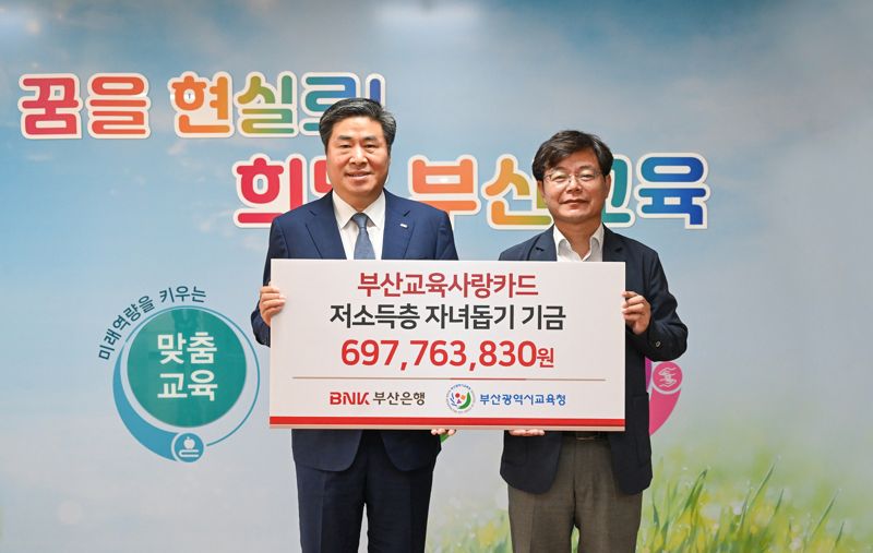 부산은행 노준섭 고객지원본부장(왼쪽)과 부산시교육청 김영진 행정국장이 저소득층 자녀돕기 기금 전달 후 기념사진을 촬영하고 있다./제공=부산은행