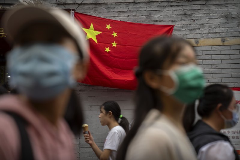 중국 베이징에 걸려있는 오성홍기 앞을 중국인들이 지나가는 모습. /사진=AP 뉴시스
