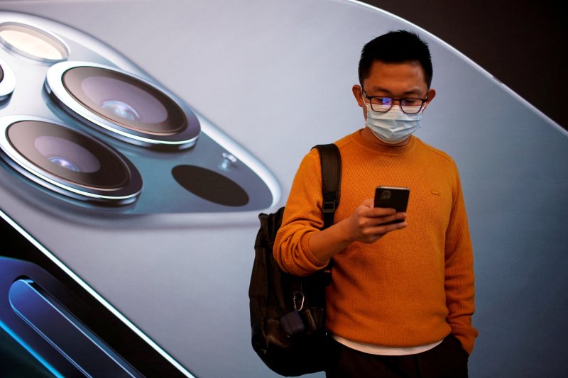 중국이 중앙부처 공무원들에게 애플 아이폰을 공용으로 사용하지 말라는 지시를 내렸다고 월스트리트저널(WSJ)이 6일(이하 현지시간) 보도했다. 2020년 10월 23일 중국 상하이 애플 스토어 앞에서 한 남성이 마스크를 쓴 채 스마트폰을 보면서 아이폰12 판매를 기다리고 있다. 로이터뉴스1