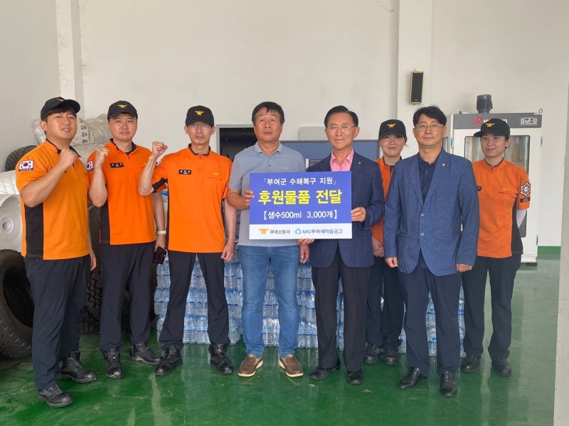 김영구 부여새마을금고 이사장(오른쪽)이 후원물품 팻말을 들고 이정교 부여소방서 의용소방대연합회장과 기념사진을 찍고 있다.(부여새마을금고 제공)/뉴스1