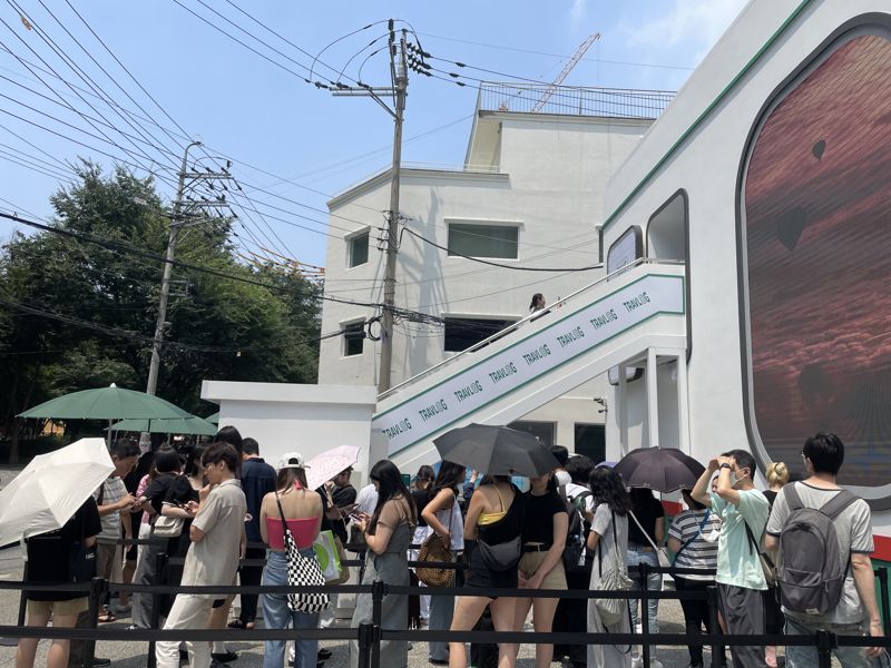 21일 서울 성동구에 위치한 하나금융 트래블로그 팝업 스토어 '성수국제공항' 앞에 방문객들이 탑승을 기다리고 있는 가운데 첫번째 방문객이 계단을 올라 비행기에 탑승하고 있다. 사진=이승연 기자