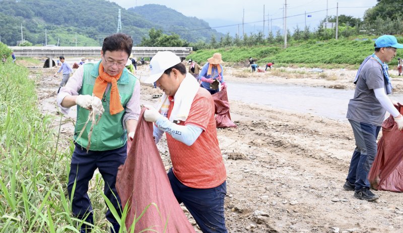 이철우 경북지사와 권영진 전 대구시장이 지난 23일 집중호우로 큰 피해를 입은 예천군 감천면 진평리에서 봉사활동을 하고 있다. 뉴스1