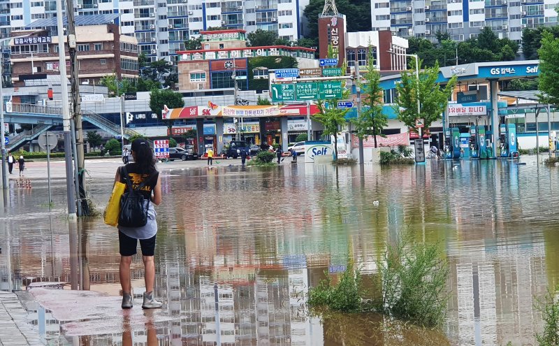 24일 오전 전남 목포시 석현동 일대가 침수되면서 한 주민이 물로 길이 막힌 도로를 바라보고 있다. 뉴시스