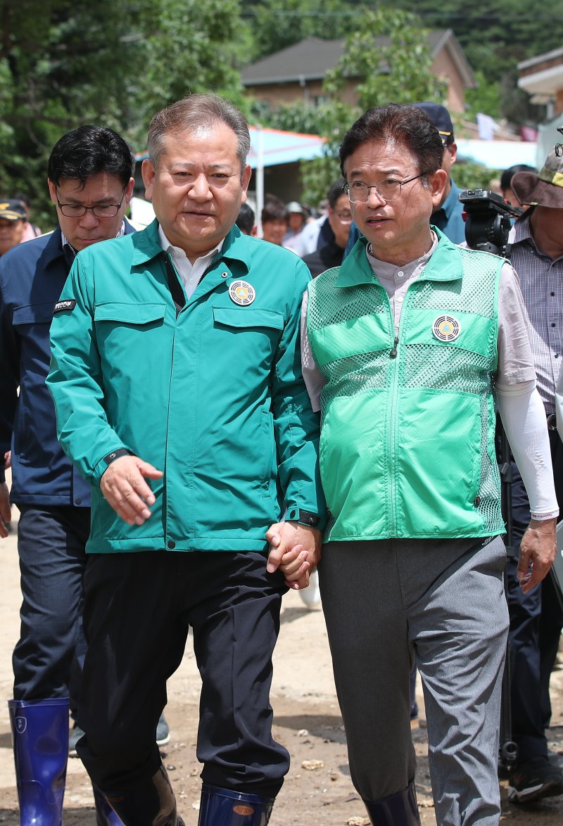 이상민 행정안전부 장관이 이철우 경북지사와 함께 26일 오후 경북 봉화군 봉성면 우곡리 집중호우와 산사태로 피해를 당한 오그래미 마을을 찾아 피해상황을 살펴보며 이 지사의 손을 잡고 위로하고 있다. 뉴스1