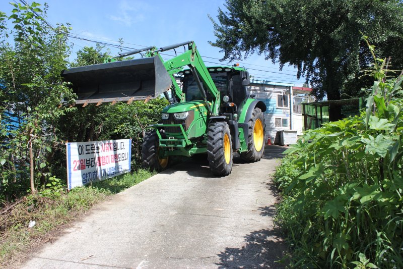 충북 청주시 서원구 현도면 중삼리에서 토지 소유자들이 사유지임을 알리며 트랙터로 길을 막고 주변 공장에서의 토지 사용을 제한하고 있다. 2023.7.26/뉴스1