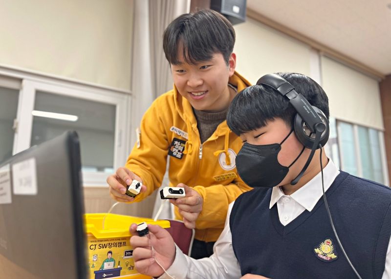 목포 영화중학교의 한 학생이 'CJ SW창의캠프'에 참여해 CJ UNIT 대학생 봉사단에게 코딩을 배우고 있다. CJ올리브네트웍스 제공