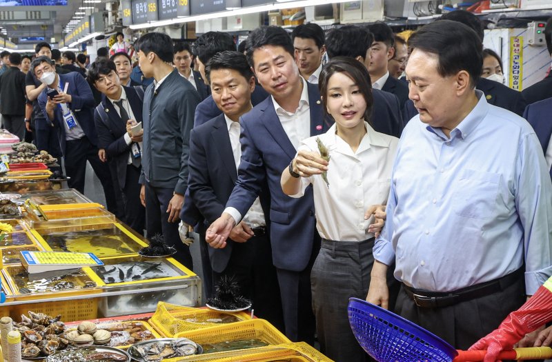 윤석열 대통령 부인 김건희 여사가 27일 부산 중구 자갈치시장을 찾아 수산물을 살펴본 뒤 새우를 들어보이고 있다. 2023.7.27/뉴스1 ⓒ News1 부산사진공동취재단