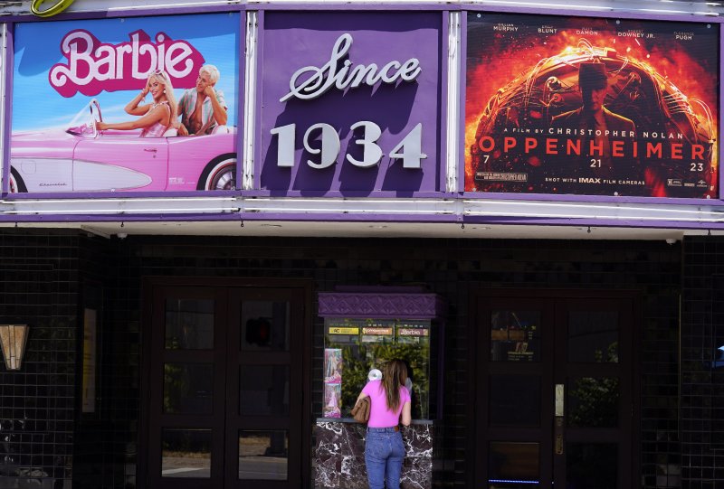 미국 영화관들이 사상최고 폭염 속에서 극장 내부는 시원하다는 날씨 마케팅과 이른바 바벤하이머라고 부르는 두 블록버스터 영화 흥행 돌풍에 힘입어 올해 큰 폭의 매출 증가세를 기록하고 있다. 지난달 28일(현지시간) 캘리포니아주 로스앤젤레스(LA)의 로스펠리스극장 위에 바비와 오펜하이머 영화 두 편의 포스터가 붙어 있는 가운데 한 관람객이 표를 끊고 있다. AP뉴시스