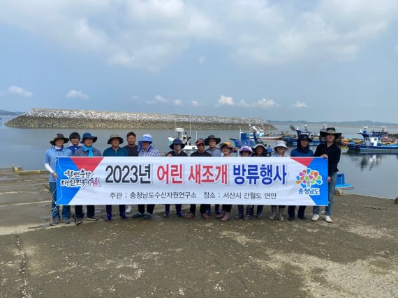 충남도 수산자원연구소 관계자들이 지난달 31일 충남 서산 천수만에 어린 새조개를 방류하기에 앞서 기념촬영을 하고 있다.