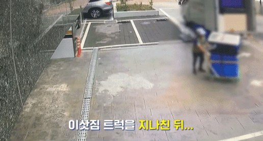 트럭 주변에 내려져있던 짐을 살펴보던 남성이 트럭을 지나쳐 수레를 어딘가로 옮기고 있다./사진=유튜브 '서울경찰'
