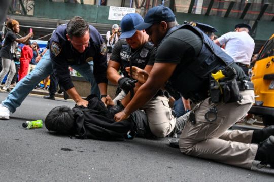 4일(현지 시각) 미국 뉴욕 맨해튼 유니언 광장에서 무료 게임기를 받으려는 군중들이 소동을 빚은 가운데, 경찰이 난동을 부린 사람을 체포하고 있다. AFP 연합뉴스