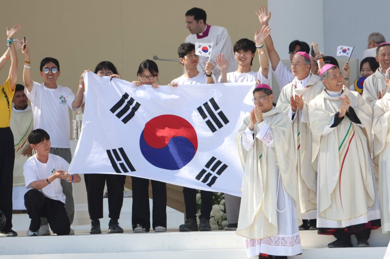 6일(현지시간) 포르투갈 리스본의 테주 공원에서 열린 올해 가톨릭 세계청년대회 폐막 미사에서 2027년 차기 대회 개최지가 서울로 발표되자 한국의 순례자들과 주교들이 무대 위에서 태극기를 펼쳐 들며 환호하고 있다. 세계청년대회는 2∼3년 주기로 가톨릭을 믿는 청년들이 한자리에 모여 신앙을 성찰하고 사회 문제를 토론하는 행사다. 연합뉴스