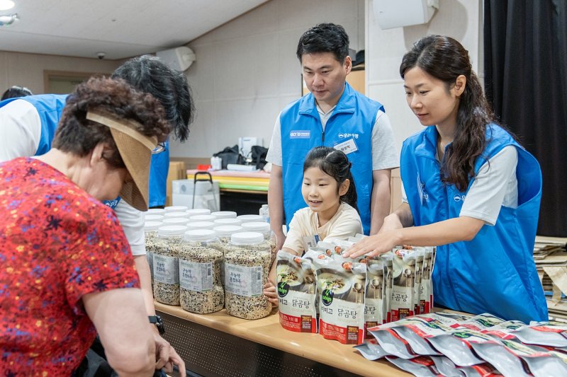 우리은행 임직원과 가족들이 지난 5일 서울 중구 '찾아가는 나눔장터'에서 어르신에게 여름나기 지원물품을 전달하고 있다. 우리은행 제공