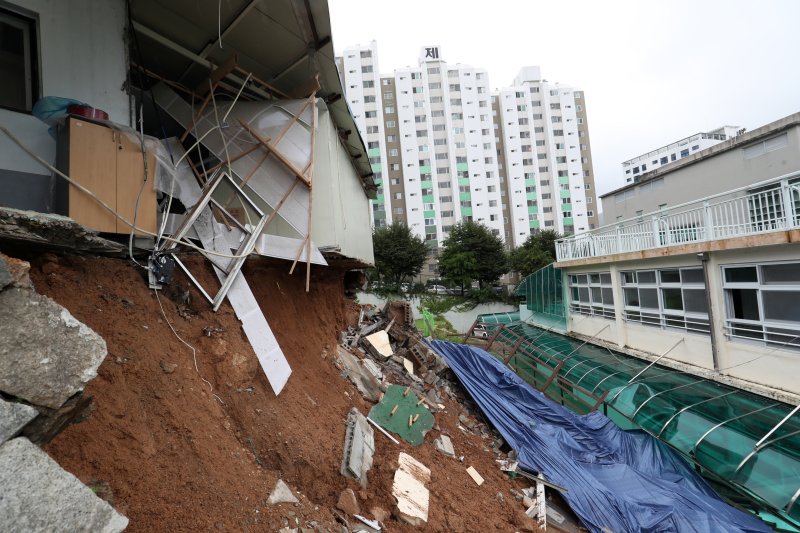 제6호 태풍 '카눈'이 지나간 10일 오후 부산 금정구 금정중학교 인근 공장의 옹벽이 태풍의 영향으로 무너지며 유출된 토사가 학교로 쏟아져 교실 등이 파손돼 있다. 이 학교는 지난달 개학했으나, 태풍 북상에 따라 이날 원격 수업을 진행해 학생 등의 인명 피해는 없었다. 2023.8.10/뉴스1 ⓒ News1 윤일지 기자