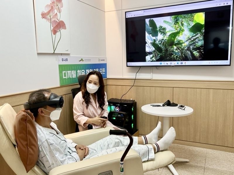 디지털 치유 정원 2호점이 설치된 '서울재활병원'에 입원 중인 환자가 국립세종수목원을 촬영한 VR 영상을 직접 체험하고 있다. 두나무 제공