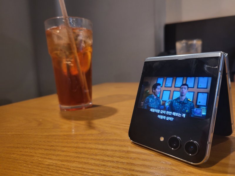 [서울=뉴시스]갤럭시 Z 플립5의 플렉스 윈도우와 프리스탑 힌지 기능을 활용해 폰을 약간 접은 채 세워 넷플릭스를 재생 중인 모습. (사진=윤현성 기자)