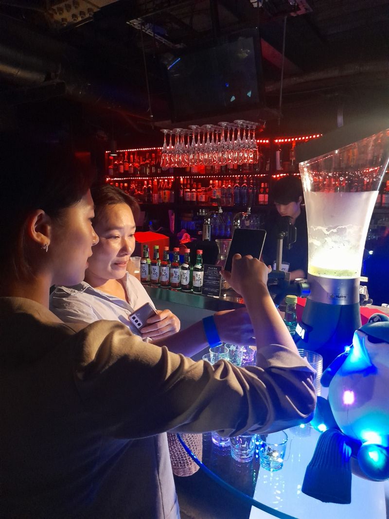 지난 3일 도쿄 시부야 한 클럽에서 '한국의 술과 음악'을 콘셉트로 농수산식품유통공사(aT)가 개최한 토크콘서트에서 참석자들이 테라 쏘맥타워를 이용하며 즐거워하고 있다.