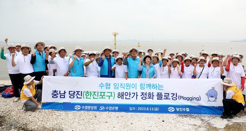 지난 11일 충남 당진시 송악읍 한진포구 일대에서 '플로깅' 활동에 참여한 참가자들이 활동에 앞서 함께 기념촬영을 하고 있다. Sh수협은행 제공