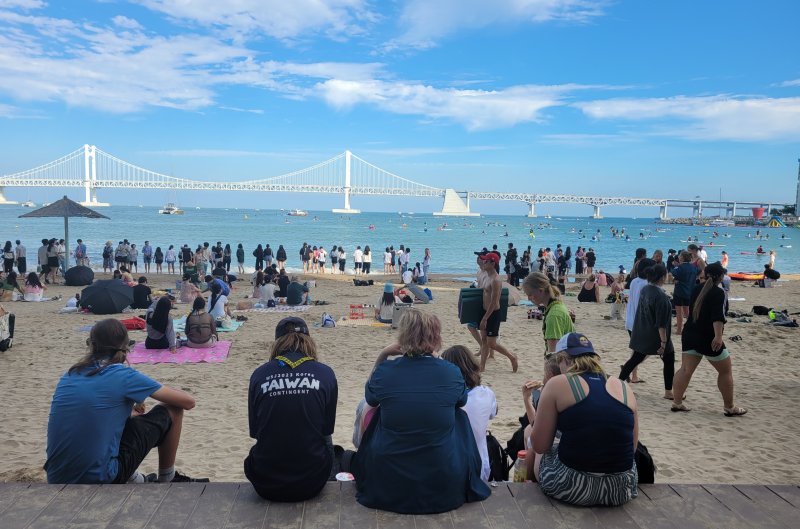 잼버리 대원들이 12일 부산 수영구 광안리해수욕장에서 광안대교를 바라보며 휴식을 취하고 있다.2023.8.12/뉴스1 ⓒ News1 조아서 기자