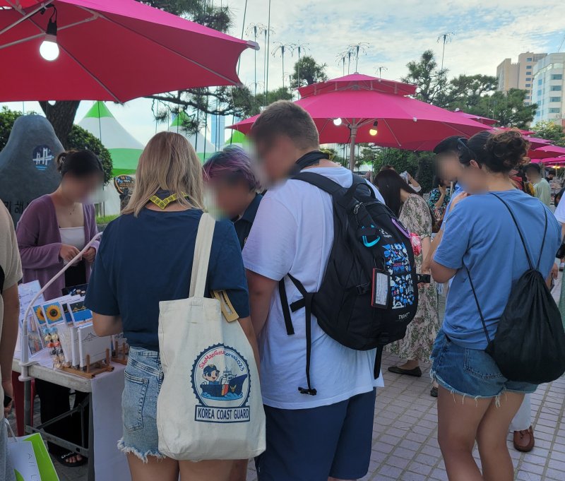 12일 부산 수영구 광안리해수욕장 일대에 열린 '광안아트마켓'에서 잼버리 대원들이 그림을 구경하고 있다.2023.8.12/뉴스1 ⓒ News1 조아서 기자