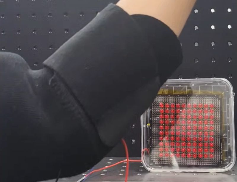 한국과학기술연구원(KIST) 전자재료연구센터 연구진이 스마트 의류용 섬유를 팔에 두른 뒤 팔을 움직이자 LED 100개에 불이 들어왔다. KIST 제공