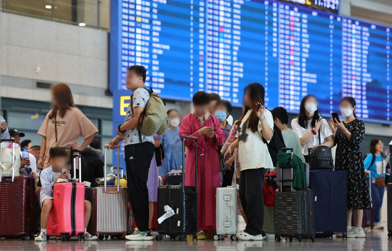 한국으로 단체 관광을 온 중국 단체 관광객들이 인천국제공항 제1여객터미널 입국장에서 가이드 안내를 기다리는 모습. 연합뉴스