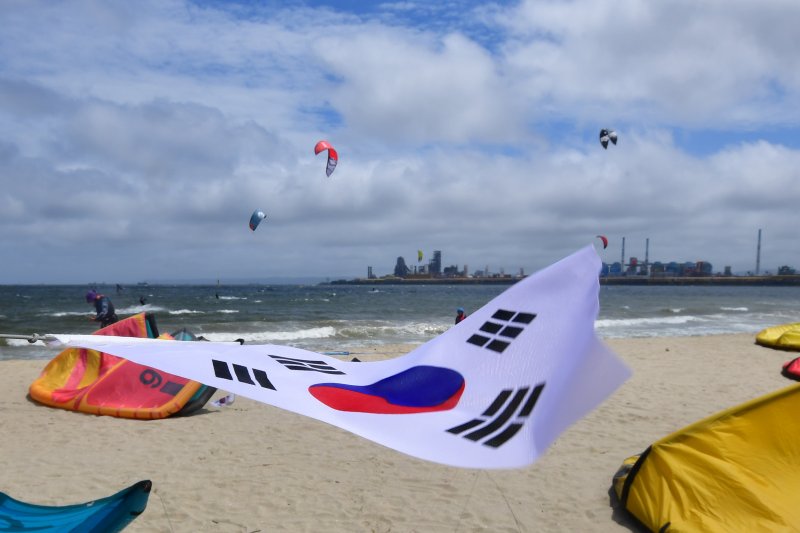 15일 경북 포항시 송도해수욕장 앞 바다에서 카이트보드 동호인들이 파도를 타고 있다. 이날 서울과 경기도, 부산 등지에서 모인 동호인들은 포항 카이트서핑센터와 함께 카이트에 태극기를 달고 광복절의 의미를 되새겼다.2023.8.15/뉴스1 ⓒ News1 최창호 기자