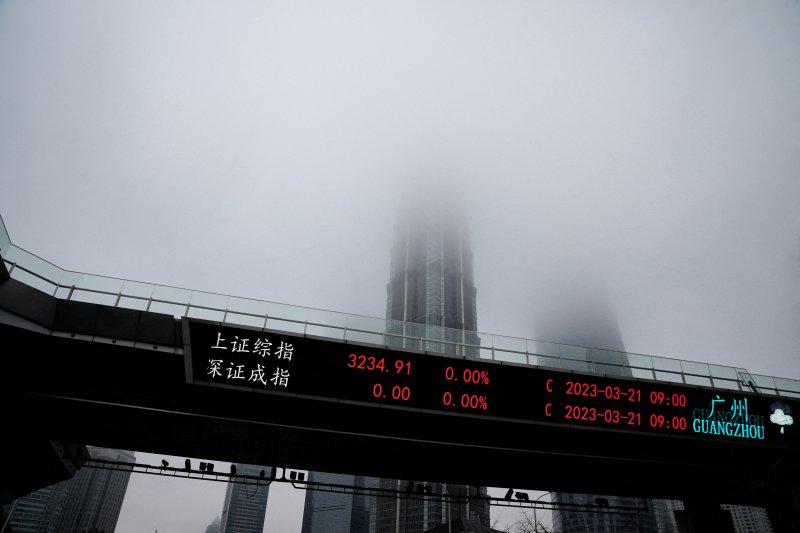 지난 3월 21일 중국 상하이의 푸둥신구 루자쭈이 금융지구에서 안개 낀 마천루 앞으로 증시 전광판이 표시되고 있다.로이터연합뉴스