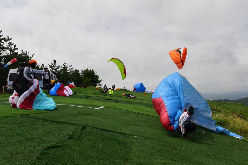 20일 경북 포항시 북구 흥해읍 곤륜산에서 포항시패러글라이딩협회원들이 전국에서 온 회원들과 함께 비행 준비를 하고 있다. 곤륜산은 전국에서 손꼽히는 패러글라이딩 장소로 알려진 곳이다.2023.8.20/뉴스1 ⓒ News1 최창호 기자