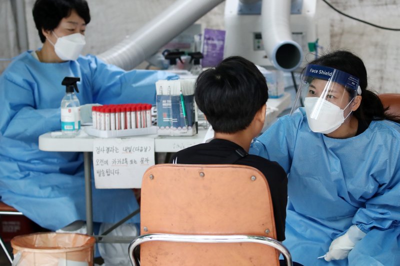 지난 21일 오전 대구 달서구 보건소에 마련된 코로나19 선별진료소에서 의료진이 시민의 검체를 채취하고 있다. 뉴스1 제공.