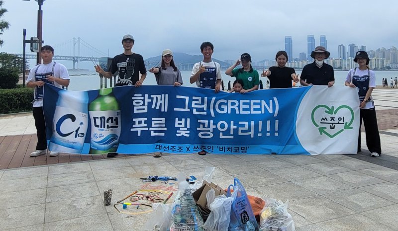 대선주조 임직원과 쓰줍인 회원들이 지난 19일 광안리 해변에서 비치코밍 행사를 갖고 기념촬영을 하고 있다. 대선주조 제공