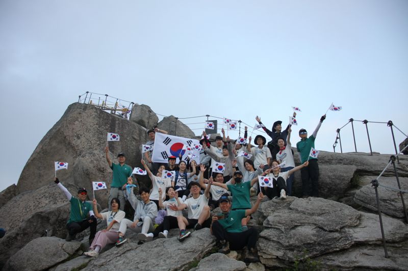 지난 18일 블랙야크강태선나눔재단 관계자와 블랙야크청년셰르파들이 북한산에서 산림 정화 캠페인 클린마운틴 활동 후 태극기 퍼포먼스를 진행하고 있다. 블랙야크 제공.