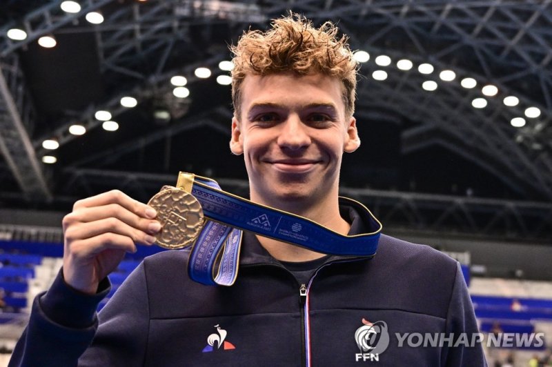 후쿠오카 세계선수권대회에서 금메달을 들어 보이는 마르샹 Gold medallist France's Leon Marchand celebrates during the medals ceremony for the men's 200m individual medley swimming event during the World Aquatics Championships in Fukuoka on July 27, 2023. (Photo by MANAN VATSYAYANA / AFP)