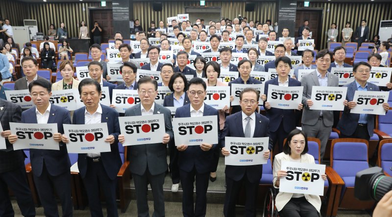 이재명 더불어민주당 대표와 박광온 원내대표를 비롯한 의원들이 24일 오전 국회에서 열린 긴급 의원총회에서 '후쿠시마 핵 오염수 해양 투기 STOP'이 적힌 피켓을 들고 구호를 외치고 있다. 뉴스1