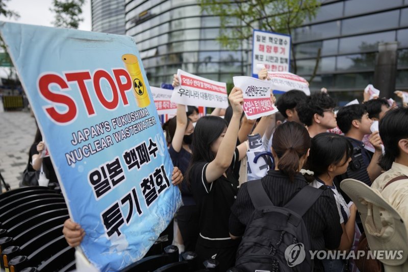 Protesters hold signs during a rally to denounce to release treated radioactive water into the sea from the damaged Fukushima nuclear power plant, outside of a building which houses Japanese Embassy, in Seoul, South Korea, Thursday, Aug. 24, 2023. The operator of the tsunami-wrecked Fukushima Daiich