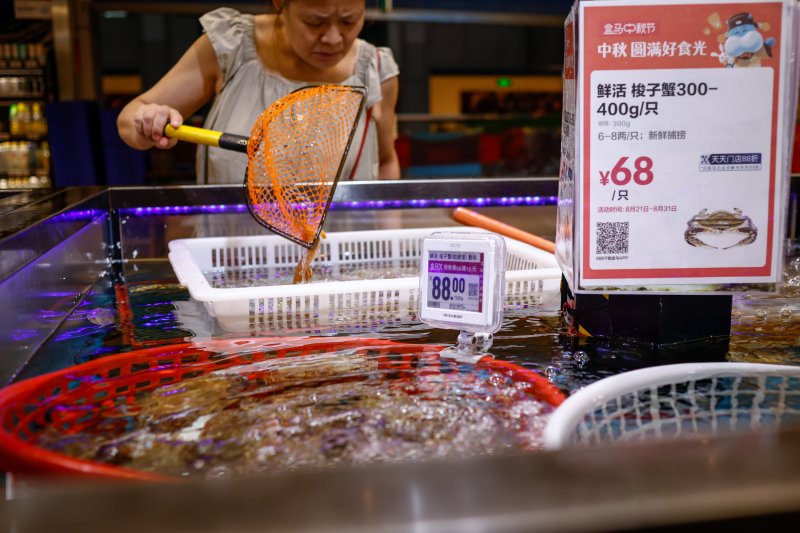지난 24일 중국 베이징의 수산물 시장에서 한 시민이 게를 살펴보고 있다.EPA연합뉴스