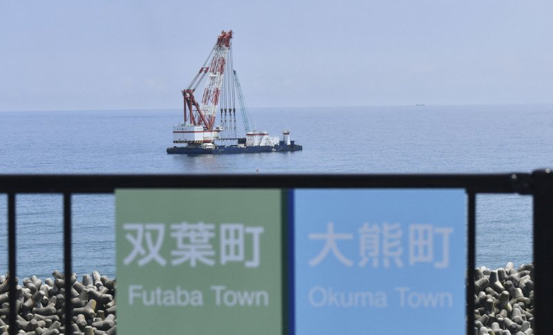 22일 일본 후쿠시마현 제1 원자력발전소 인근에 떠 있는 크레인 선박을 배경으로 후타바 마을과 오쿠마 마을의 표지판이 나란히 붙어 있다. 2023.08.22/ ⓒ 로이터=뉴스1 ⓒ News1 권진영 기자