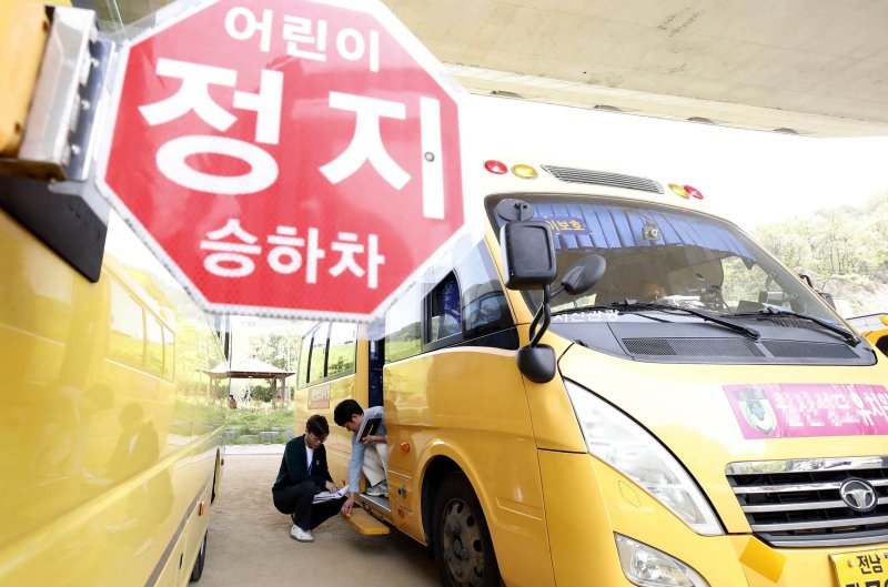 17일 광주 북구 시화문화마을문학관 주차장에서 열린 어린이 통학버스 합동 점검에서 북구 아동청소년과, 교통과, 유관기관 관계자들이 학원, 체육시설, 지역아동센터 통학차량의 안전점검을 실시하고 있다. 뉴스1