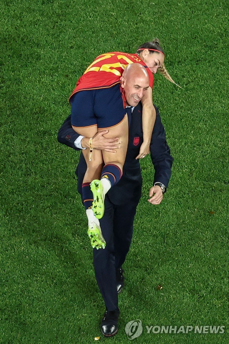 우승 후 선수를 어깨에 태우고 기뻐하는 루비알레스 회장. This picture taken on August 20, 2023 shows President of the Royal Spanish Football Federation Luis Rubiales carrying Spain's Athenea del Castillo Beivide on his shoulder as they celebrate winning the Australia and New Zealand 2023 Women's World Cup final football mat