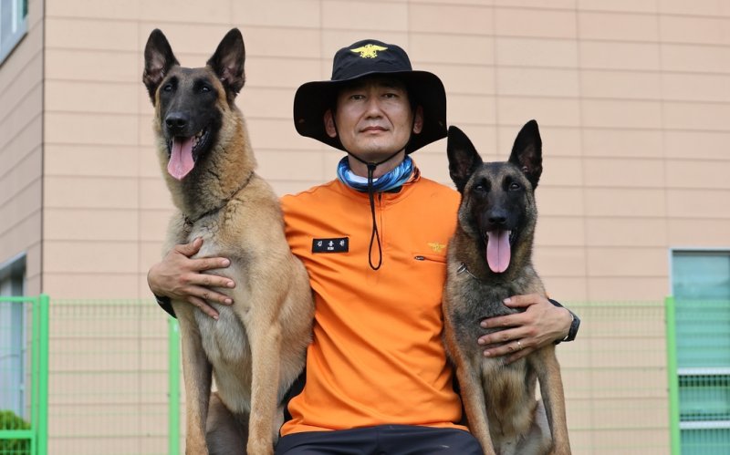 국내 1·2호 수난탐지견 파도, 규리. 왼쪽이 파도, 오른쪽이 규리. 대구 달성군 중앙119구조본부 119구조견교육대 소속 김용완 교관과 사진 찍은 모습. 사진=연합뉴스