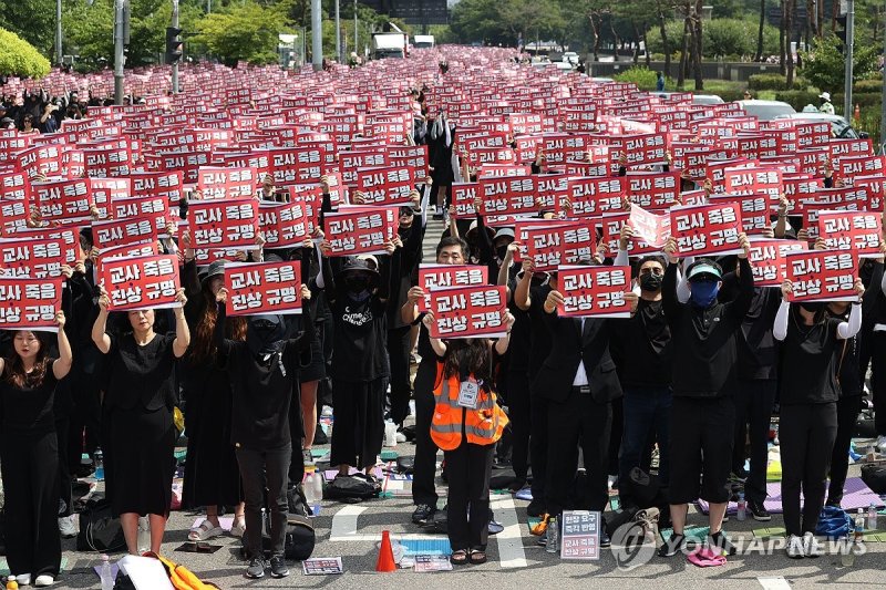 26일 오후 서울 영등포구 국회 앞에서 전국교사일동이 연 '국회 입법 촉구 추모집회'에서 참가자들이 손팻말을 들고 있다. 연합뉴스